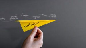 customer journey experience concept hand raise up paper plane against wall 800x450 1 300x169